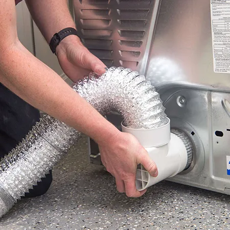 Hands holding flexible dryer vent duct during routine dryer vent maintenance and cleaning in Janesville WI.