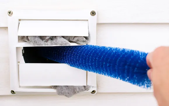 Clogged dryer vent cleaning service using specialized brush tool to clear lint buildup in Oshkosh WI.