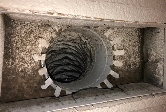 Close-up of mold and dust accumulation inside bathroom exhaust duct requiring effective mold removal in Fond Du Lac WI.