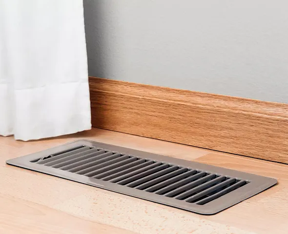 Close-up of clean floor vent grill on hardwood floor representing non-toxic air duct sanitization in Waukesha WI.