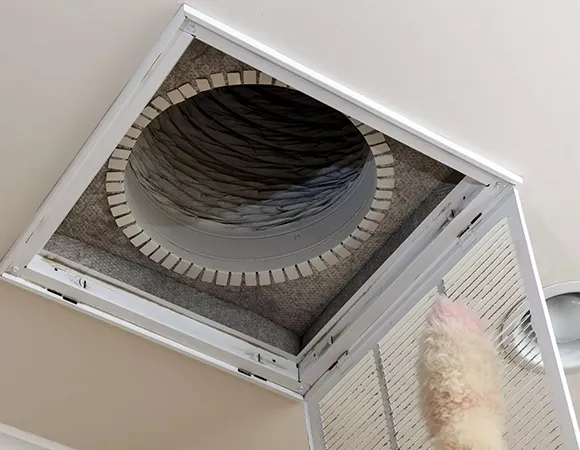 Emergency air duct cleaning service removing ceiling vent grille to access duct in West Bend WI.
