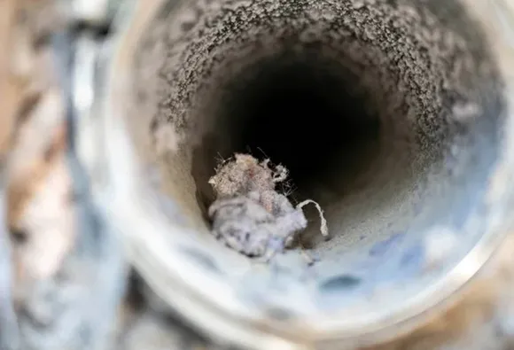 Essential dryer vent maintenance service showing buildup of lint and debris inside vent duct in West Bend WI.