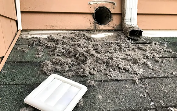 Expert dryer vent cleaning service showing cleaned clogged dryer vent with lint removed in West Bend WI.