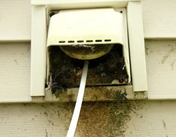 Damaged and disconnected indoor dryer vent hose with lint accumulation requiring expert dryer vent repair in Appleton WI.
