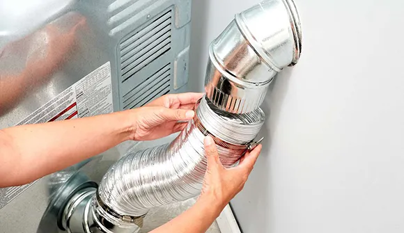 Hand adjusting flexible dryer vent pipe for preventive maintenance service.
