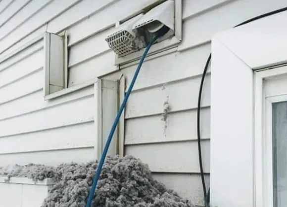 Exterior residential dryer vent covered with lint buildup requiring professional cleaning in Oshkosh WI.