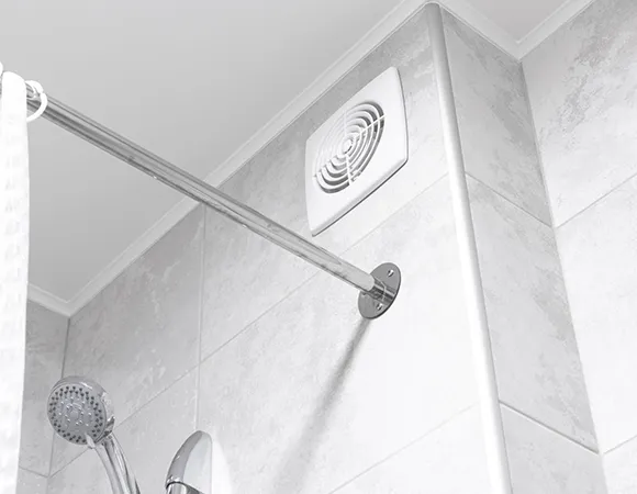 Bathroom ceiling exhaust fan installed above showerhead during thorough exhaust cleaning in Madison WI.