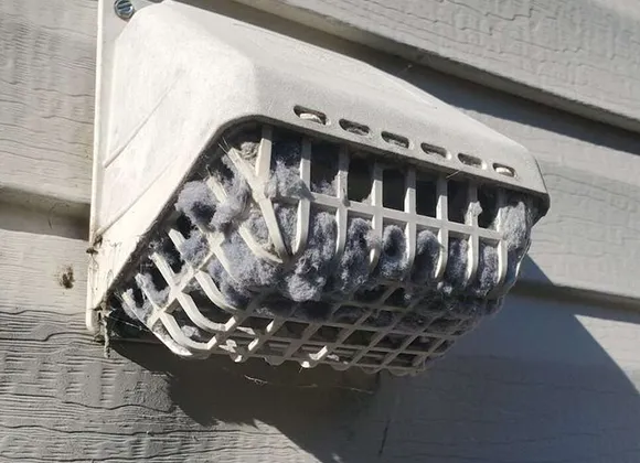 Clogged outdoor dryer vent exhaust heavily blocked by lint needing professional cleaning in Waukesha WI/