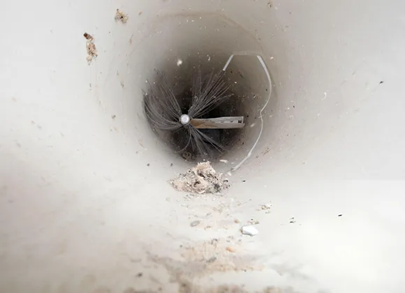 Interior of an air duct showing dust buildup and dirt before professional cleaning.